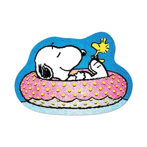 Puede incluir: Una pegatina troquelada que muestra al perro de dibujos animados blanco Snoopy con orejas negras y un pájaro amarillo descansando dentro de un flotador inflable rosa con lunares amarillos, sobre un fondo azul brillante con textura.