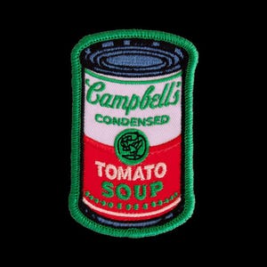 May include: An embroidered patch shaped like a soup can with a green border. The design features the text Campbell's CONDENSED TOMATO SOUP in green embroidery on a white and red background, with a small green circular emblem in the center.