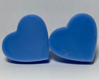 Pode incluir: Dois objetos de plástico em forma de coração de cor azul. Um coração tem uma superfície lisa, enquanto o outro tem uma superfície texturizada.