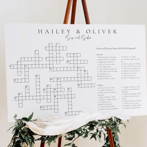 May include: A white crossword puzzle game with the names Hailey & Oliver at the top. The crossword puzzle is designed for guests to learn more about the bride and groom. The questions are listed on the right side of the puzzle.