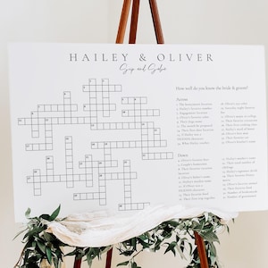 May include: A white crossword puzzle game with the names Hailey & Oliver at the top. The crossword puzzle is designed for guests to learn more about the bride and groom. The questions are listed on the right side of the puzzle.