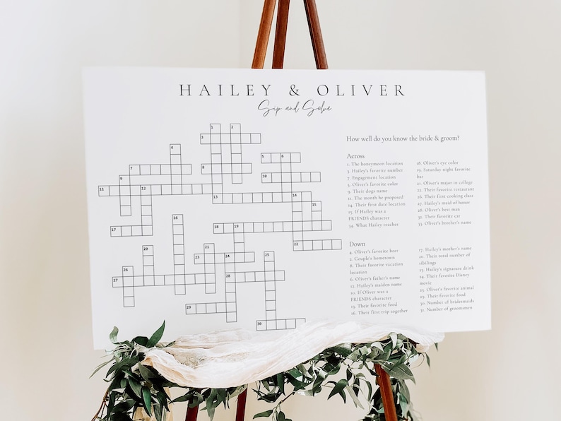 May include: A white crossword puzzle game with the names Hailey & Oliver at the top. The crossword puzzle is designed for guests to learn more about the bride and groom. The questions are listed on the right side of the puzzle.