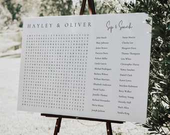 May include: A white sign with the words "Hayley & Oliver Sep 6 Search" at the top. Below the title is a word search puzzle with the names of wedding guests. The names are listed in two columns on the right side of the sign.