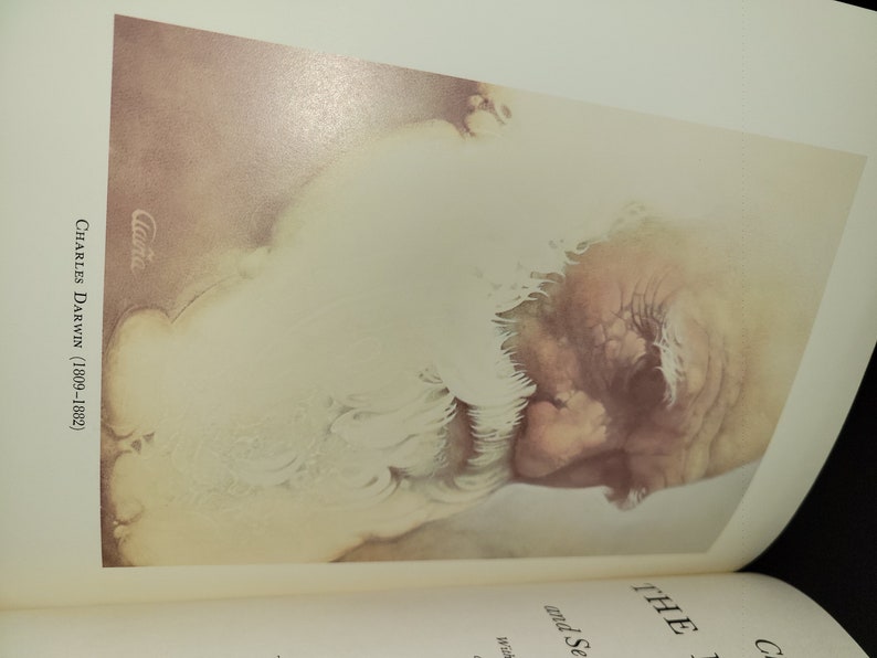 May include: A close-up portrait of Charles Darwin, a famous scientist, in a watercolor style. The image is in shades of brown, white, and gray. The text "Charles Darwin (1809-1882)" is written in the lower left corner of the image.