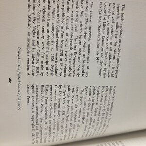 Puede incluir: Primer plano de una p&aacute;gina de libro con texto sobre la historia de Las Mil y Una Noches. El texto menciona los primeros manuscritos supervivientes, la primera traducci&oacute;n europea y las diferentes versiones publicadas en varios idiomas.