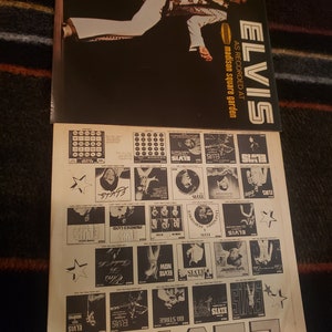May include: A vintage vinyl record album cover featuring Elvis Presley. The cover is black with white text that reads "ELVIS" and "AS RECORDED AT MADISON SQUARE GARDEN". The album cover features a black and white photo of Elvis Presley performing on stage.