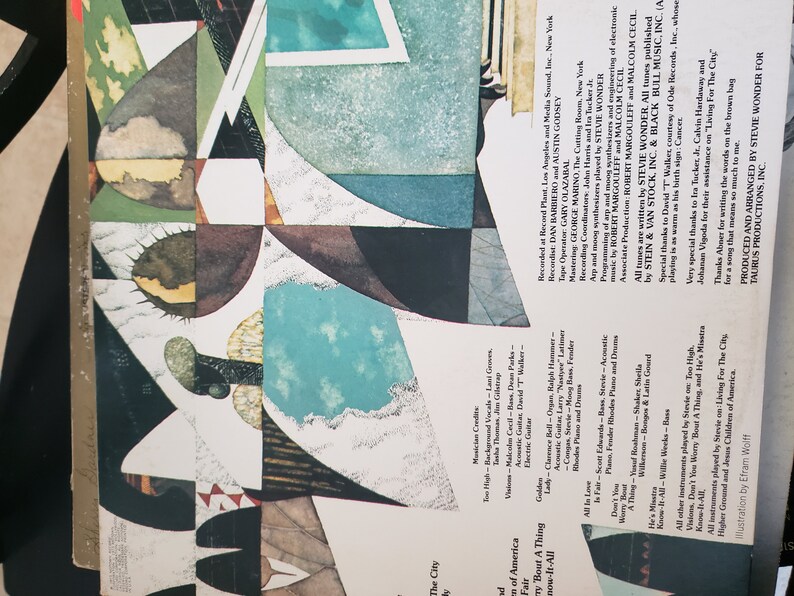 Puede incluir: La contraportada de un &aacute;lbum de vinilo con un dise&ntilde;o abstracto colorido. El &aacute;lbum se titula "Stevie Wonder - Songs in the Key of Life". Los cr&eacute;ditos del &aacute;lbum incluyen los nombres de los m&uacute;sicos, productores e ingenieros. El texto de la contraportada tambi&eacute;n incluye un agradecimiento a las personas que ayudaron a hacer posible el &aacute;lbum.