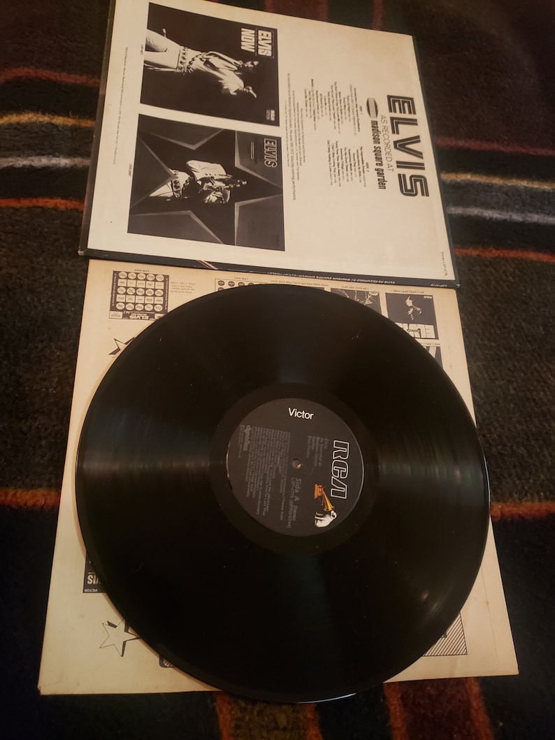 May include: A black vinyl record with a white RCA label. The record is titled "Elvis As Recorded At Madison Square Garden". The album cover features a black and white photo of Elvis Presley.