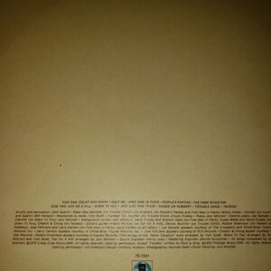 Puede incluir: La contraportada de un &aacute;lbum de vinilo de Joni Mitchell. El &aacute;lbum se titula "Court and Spark" y presenta una foto de Joni Mitchell en la portada. El &aacute;lbum fue lanzado en 1974 en Asylum Records. La contraportada enumera las canciones del &aacute;lbum, los m&uacute;sicos que tocaron en el &aacute;lbum y los cr&eacute;ditos del &aacute;lbum.