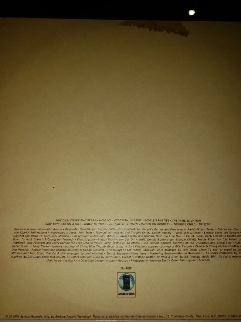 Puede incluir: La contraportada de un &aacute;lbum de vinilo de Joni Mitchell. El &aacute;lbum se titula "Court and Spark" y presenta una foto de Joni Mitchell en la portada. El &aacute;lbum fue lanzado en 1974 en Asylum Records. La contraportada enumera las canciones del &aacute;lbum, los m&uacute;sicos que tocaron en el &aacute;lbum y los cr&eacute;ditos del &aacute;lbum.