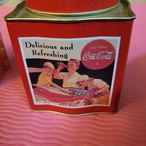 Puede incluir: Una lata roja de Coca-Cola con un dise&ntilde;o vintage que muestra a un grupo de personas disfrutando de Coca-Cola con hielo. La lata tiene el texto "Delicious and Refreshing" y "Ice-Cold Coca-Cola".