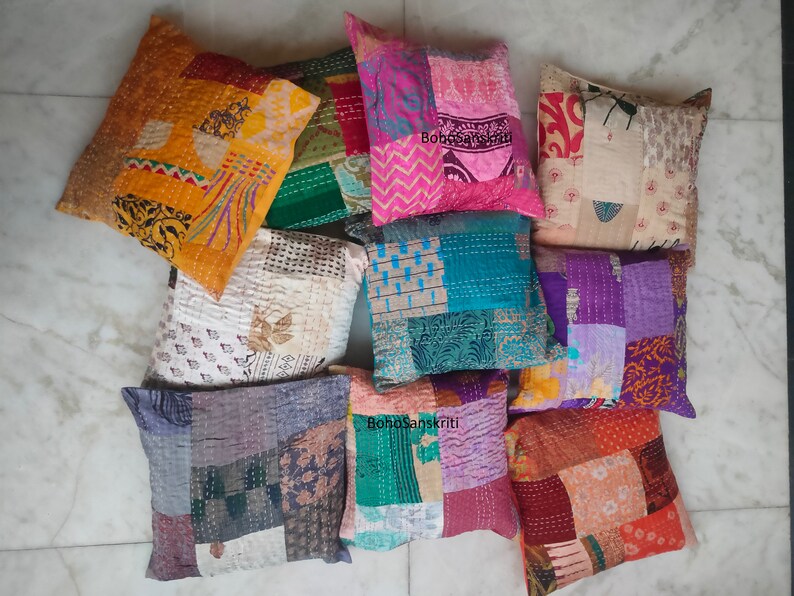 May include: A collection of nine colorful patchwork pillow covers with various patterns and textures. The pillow covers are made from recycled saris and are perfect for adding a touch of bohemian style to any room.
