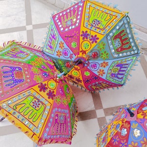 Puede incluir: Tres paraguas coloridos con dise&ntilde;os bordados que representan elefantes, flores y patrones geom&eacute;tricos. Los paraguas est&aacute;n hechos de tela y tienen un estilo tradicional indio.