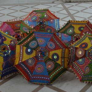 May include: Six colorful umbrellas with intricate patterns and embellishments. The umbrellas are made of fabric and have a variety of colors, including red, blue, green, yellow, and pink. They are decorated with sequins, beads, and other embellishments.