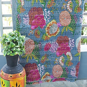 K&ouml;nnte beinhalten: Eine graue Kantha-Steppdecke mit einem floralen Muster in Rosa-, Gelb-, Gr&uuml;n- und Oranget&ouml;nen. Die Steppdecke ist handgen&auml;ht und hat einen Vintage-Look.