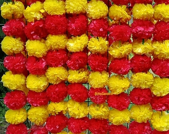 Könnte beinhalten: Eine Girlande aus abwechselnd roten und gelben Stoffblumen. Die Blumen sind in Reihen angeordnet und an einer Schnur befestigt. Die Girlande ist perfekt zum Dekorieren für eine Party oder einen besonderen Anlass.