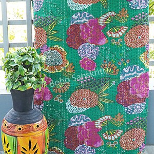 K&ouml;nnte beinhalten: Eine gr&uuml;ne Kantha-Steppdecke mit einem floralen Muster in Rosa-, Orange- und Lilat&ouml;nen. Die Steppdecke ist handgen&auml;ht und hat einen einzigartigen Vintage-Look.