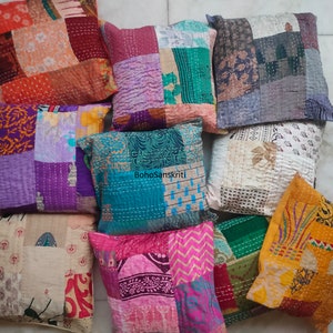 May include: A collection of ten colorful patchwork throw pillows with various patterns and textures. The pillows are made from recycled saris and are perfect for adding a touch of bohemian style to any room.