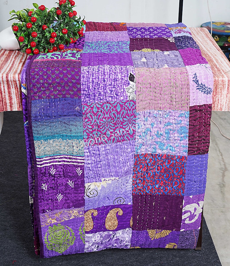 May include: A purple and blue patchwork quilt with a variety of patterns. The quilt is made of silk and is hand-stitched. It is a beautiful and unique piece of art.