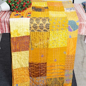 Könnte beinhalten: Eine gelbe und braune Patchwork-Decke mit verschiedenen Mustern und Texturen. Die Decke ist aus Seide und handgenäht. Es ist ein wunderschönes und einzigartiges Kunstwerk.