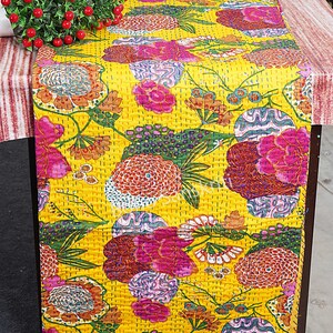 May include: Yellow kantha quilt featuring a floral design in shades of pink, green, and orange. The quilt is made from cotton and is hand-stitched.