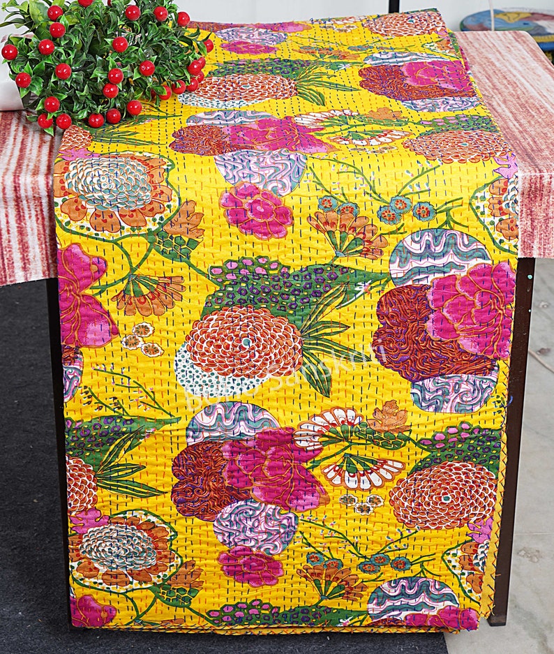 May include: Yellow kantha quilt featuring a floral design in shades of pink, green, and orange. The quilt is made from cotton and is hand-stitched.