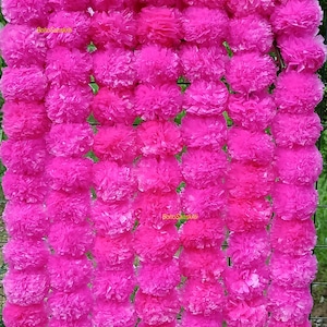 May include: A vibrant display of bright pink paper flowers, arranged in a dense, vertical pattern. The flowers have a textured, ruffled appearance, creating a full and visually appealing arrangement. The overall effect is a cheerful and decorative floral display.