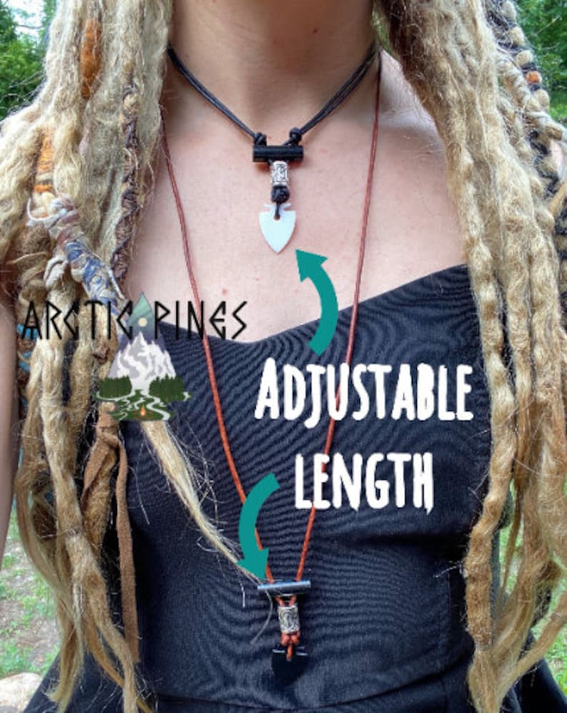 May include: Two necklaces with adjustable length. The top necklace is black with a white arrowhead pendant. The bottom necklace is brown with a black pendant. The text "ADJUSTABLE LENGTH" is in white.