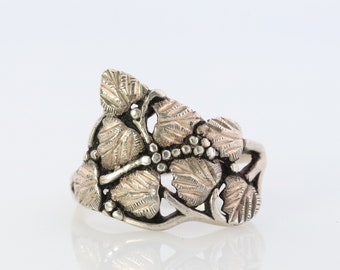 May include: A silver ring featuring a design of leaves and vines. The ring is made from sterling silver and has a polished finish.