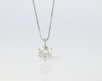 May include: A silver chain necklace with a large, clear, round diamond pendant.