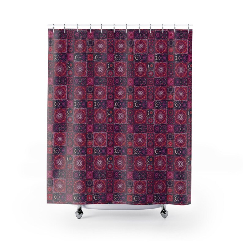 May include: A patterned shower curtain with a repeating design of squares in shades of burgundy, pink, and purple. Each square features a circular mandala pattern and a crescent moon. The curtain hangs from a metal rod.