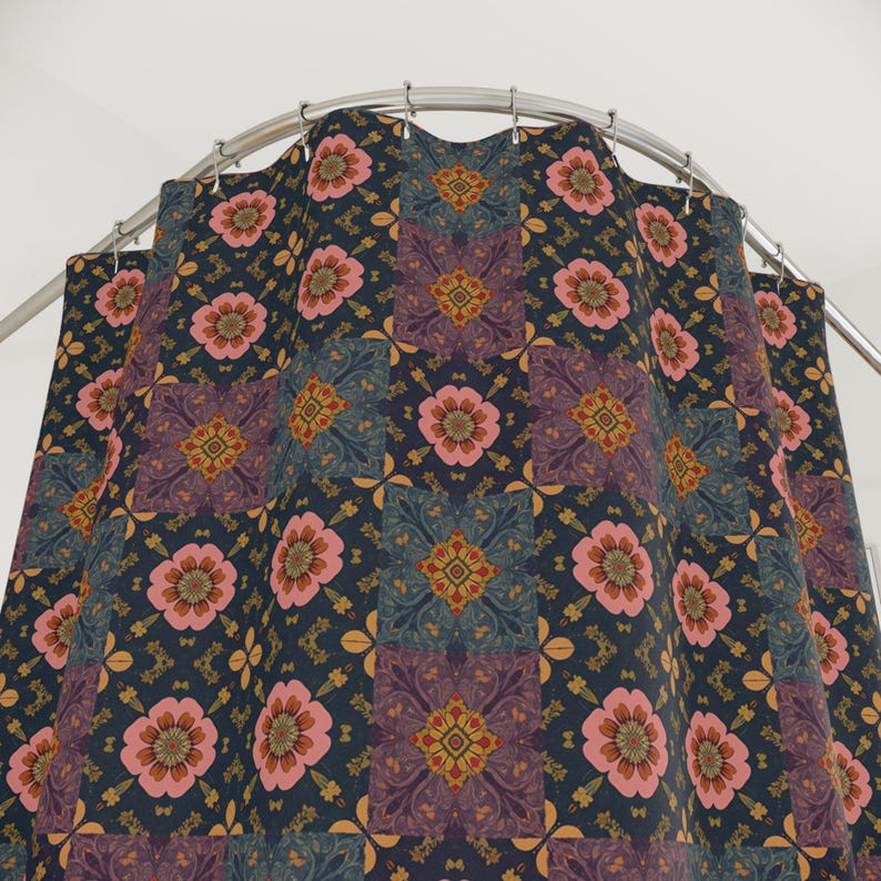 May include: A patterned shower curtain with a dark blue background. The design features repeating squares with pink flowers, teal and purple geometric shapes, and gold accents. The curtain hangs from a curved, silver shower rod.