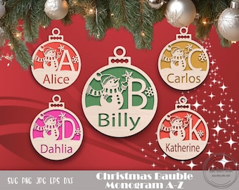 May include: Five wooden Christmas ornaments with a snowman design and a letter of the alphabet. The ornaments are painted in various colors, including pink, green, and brown. The ornaments are labeled with the names Alice, Dahlia, Billy, Carlos, and Katherine.
