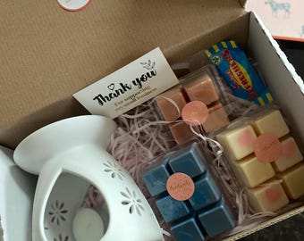 May include: A gift box filled with wax melts, a wax warmer, and a thank you card. The wax melts are in various colors and scents, including "Lavender" and "Sunshine". The card says "Thank you for supporting my small business".