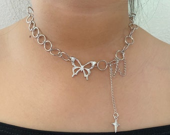 Op de afbeelding: Zilveren ketting choker met een vlinder hanger en een hangende ster bedel.