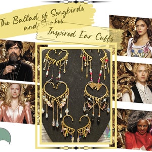 May include: Three pairs of gold ear cuffs with dangling charms and beads. The ear cuffs are inspired by the movie "The Ballad of Songbirds and Snakes".