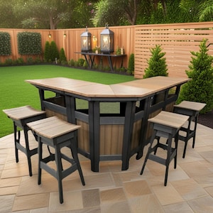 May include: An outdoor L-shaped bar with matching bar stools. The bar has a light brown countertop and a black and brown base. The stools have light brown seats and black legs. The bar is set on a stone patio with a green lawn in the background.