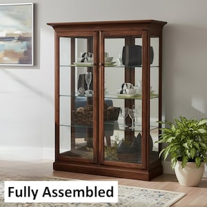May include: A dark brown wooden display cabinet with glass doors and shelves. The cabinet is filled with decorative items, including dishes, glasses, and baskets. The text "Fully Assembled" is at the bottom.