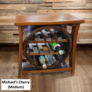 May include: A wooden wine rack with a tabletop, featuring a circular wine bottle holder. The rack is made of dark brown wood and holds several wine bottles. The text "Michael's Cherry (Medium)" is visible at the bottom.