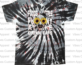 Könnte beinhalten: Schwarz-weiß-graues Batik-T-Shirt mit dem Text "FOODS A LITTLE FUNNY AT THE CLOWN CAFE" und einer Clownschädel-Grafik mit Sonnenblumenbrille. Das Shirt hat auch den Text "VIBES CUSTOM APPAREL".