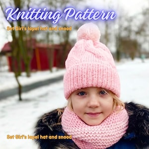 May include: Knitting pattern for a pink hat and matching scarf set. The hat has a pompom on top and the scarf is a cowl style.