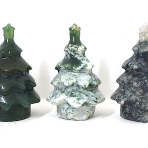 May include: Three carved agate Christmas tree ornaments. The trees are green, white and green, and black and green.