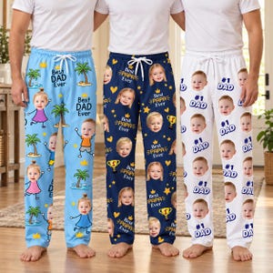 May include: Three pairs of lounge pants with white drawstring waists. The light blue pair features palm trees and the text Best Dad Ever. The navy pair features gold stars, trophies, and Best Papa Ever. The white pair features #1 DAD text.