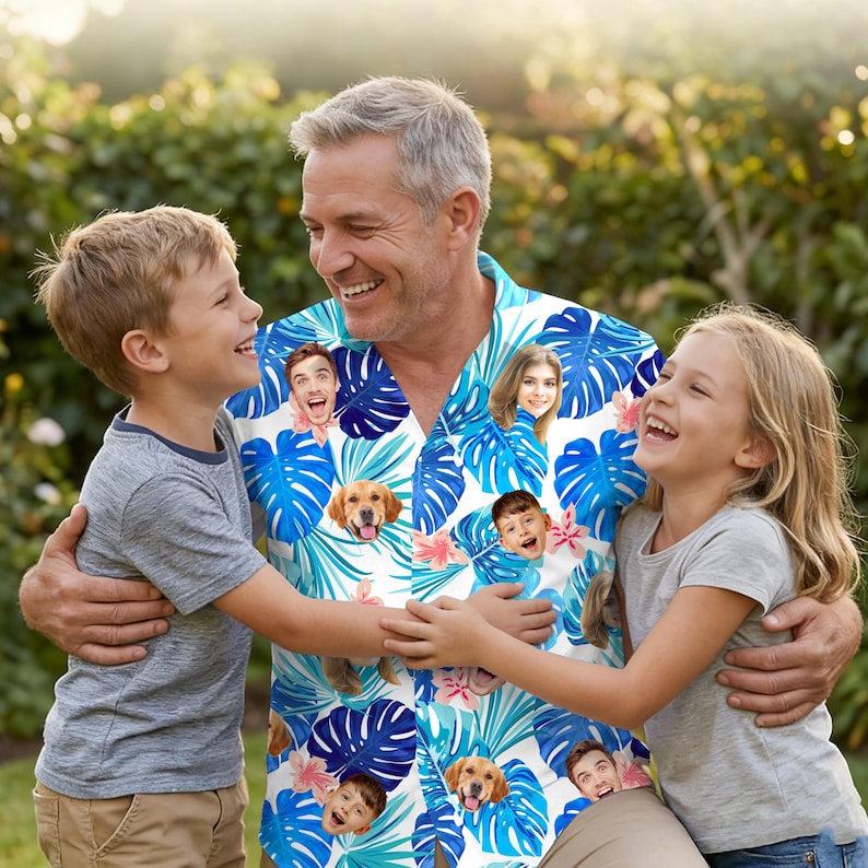 May include: A short-sleeved button-down shirt featuring a vibrant tropical pattern of blue monstera leaves and pink flowers, interspersed with repeating photographic portraits of faces and a golden retriever dog on a white background.