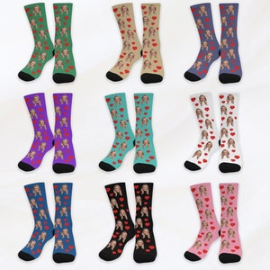 May include: A set of 10 pairs of socks with a variety of colors and patterns. Each pair features a repeated image of a person's face with red hearts.