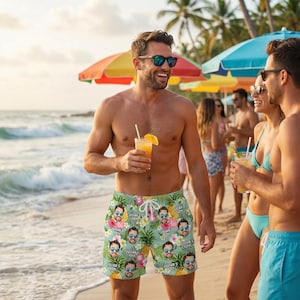 May include: A man wearing sunglasses and personalized swim trunks with a tropical floral pattern and faces. He is holding a cocktail with an orange slice. The background includes a beach, ocean, and colorful umbrellas.