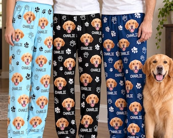 May include: Three pairs of lounge pants in light blue, black, and dark blue, each featuring a repeating pattern of a golden retriever's face, the name Charlie, and paw prints. The pants are worn by three individuals in white t-shirts.