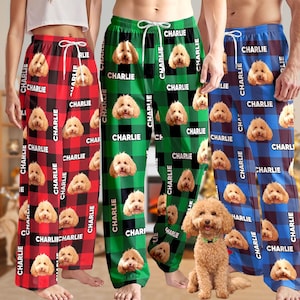 May include: Pajama pants in red, green, and blue plaid patterns, each featuring a repeating image of a dog's face and the name "CHARLIE" in white text. The pants have a drawstring waist.