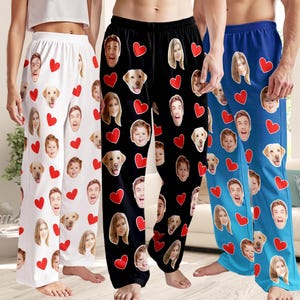 May include: Three pairs of pajama pants in white, black, and blue. Each pair features a repeating pattern of red hearts and custom faces. The pajama pants are made of a soft, comfortable material.