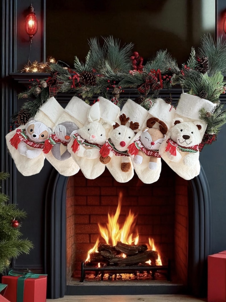 May include: Six festive Christmas stockings, each adorned with a different soft toy animal wearing a red and green scarf. The white stockings hang above a fireplace decorated with festive greenery and lights, creating a warm holiday atmosphere.